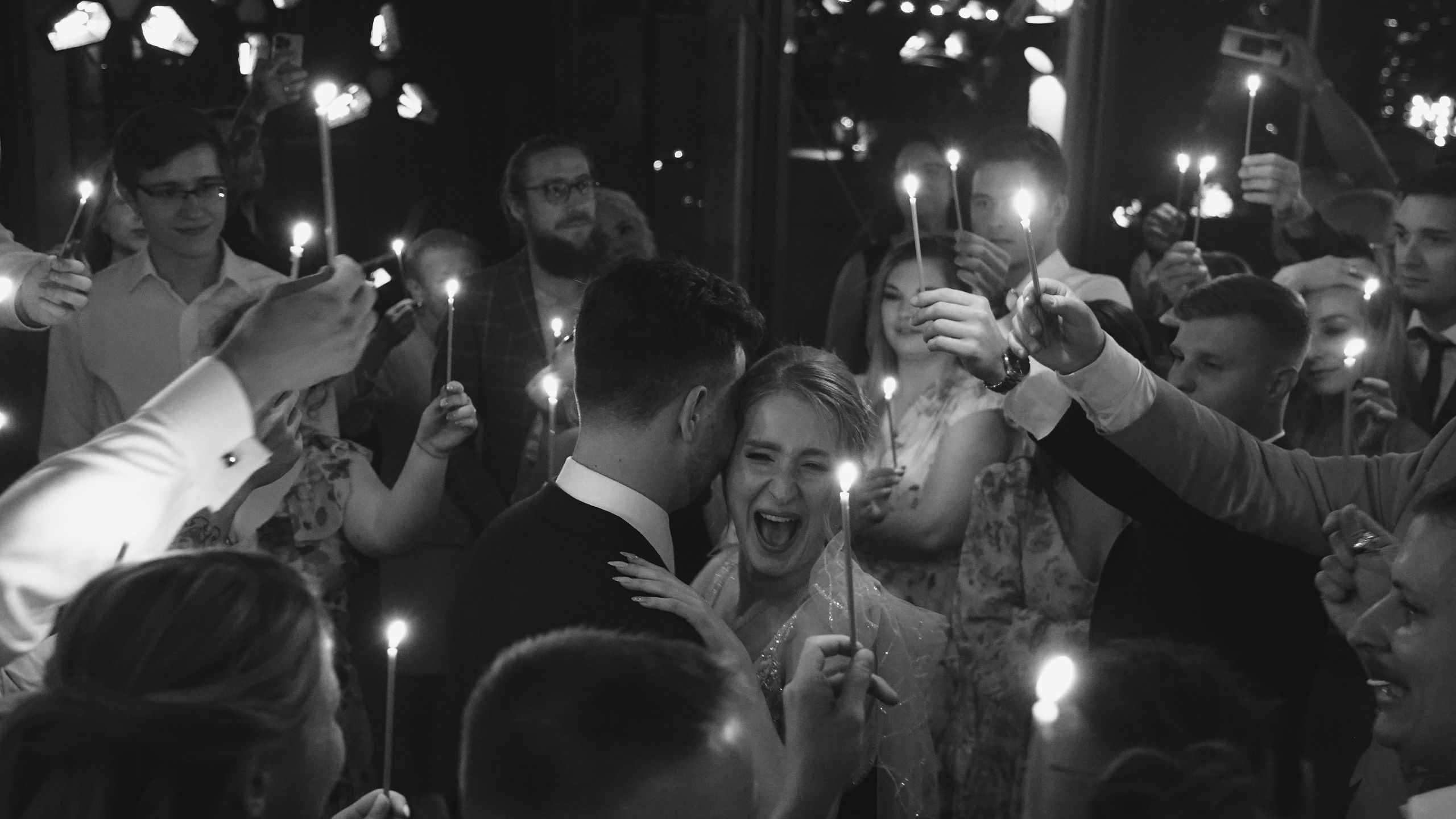 Goście z zimnymi ogniami wokół pary młodej na weselu - reportaż ślubny